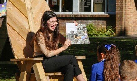 Children in the playground whilst teacher reads