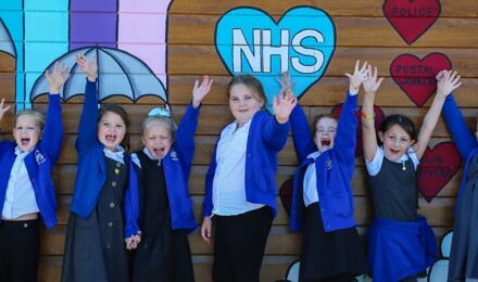 Children standing in line waving