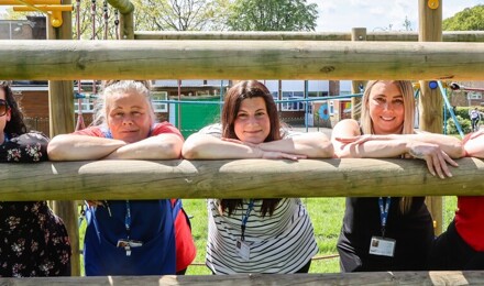 Teachers leaning on wooden fence