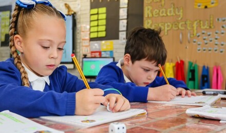 Two children writing in classroom